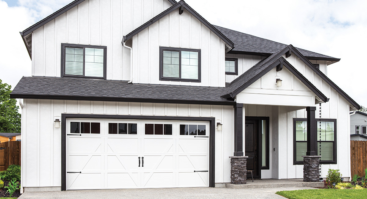 white carriage house garage door with 12 square windows on white home