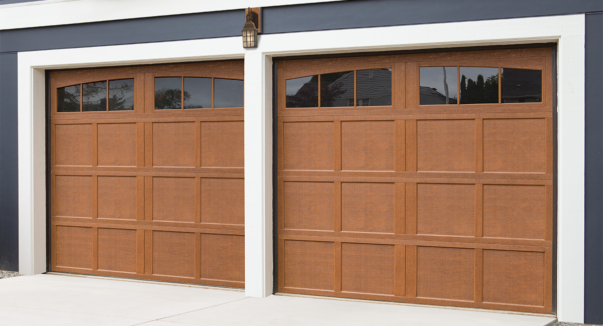 natural oak carriage house garage door with 12 arch windows and small light above garage door