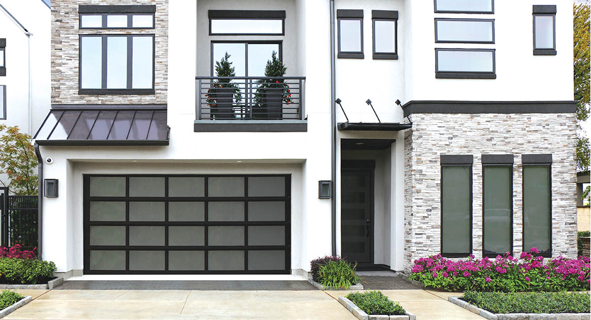 modern house with aluminum black garage door and flowers