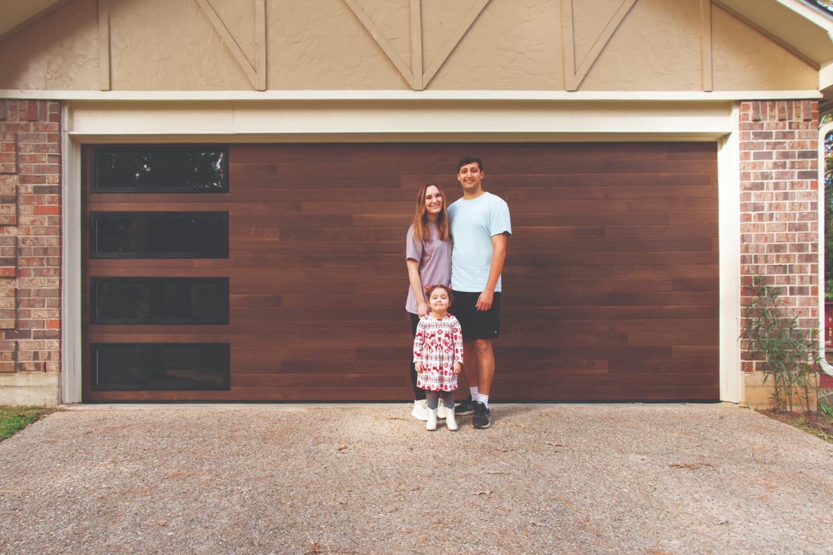 Family standing in front of Wayne Dalton 8300AG medium oak garage door