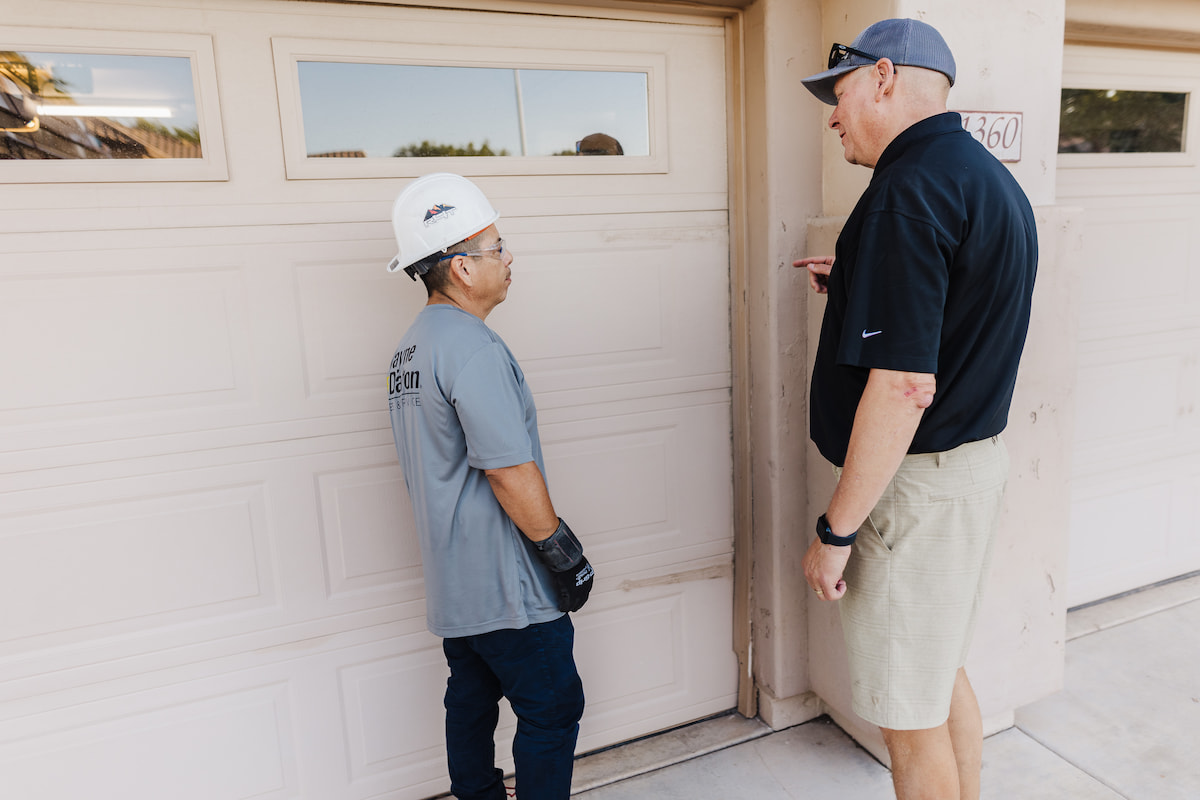 Wayne Dalton Sales & Service technician reviewing maintenance inspection with homeowner