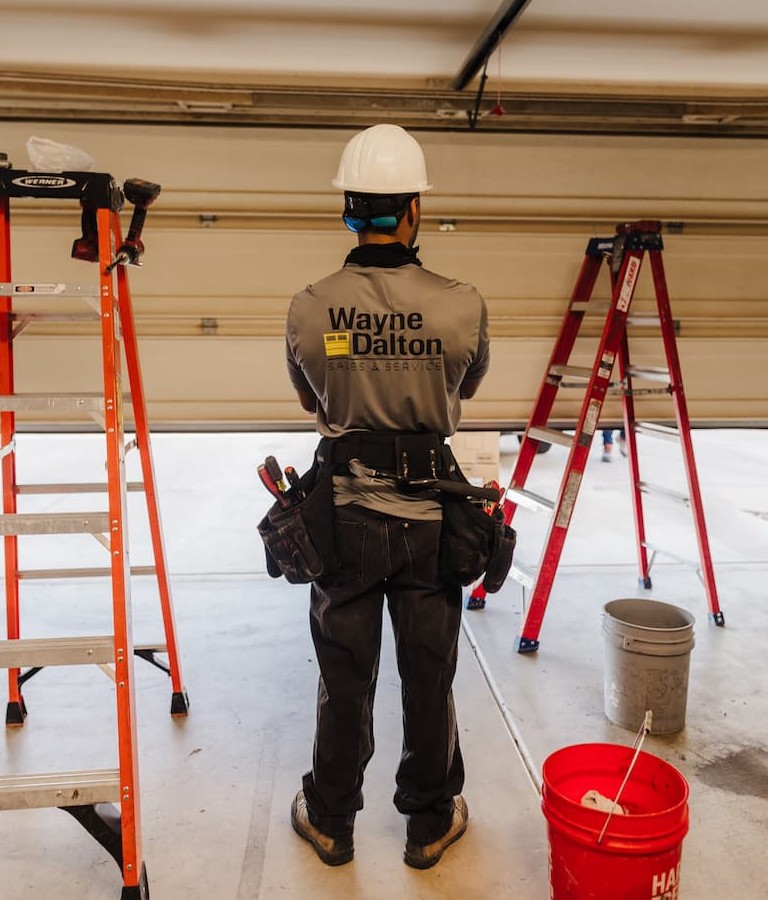 Wayne Dalton Sales & Service technician examining garage door