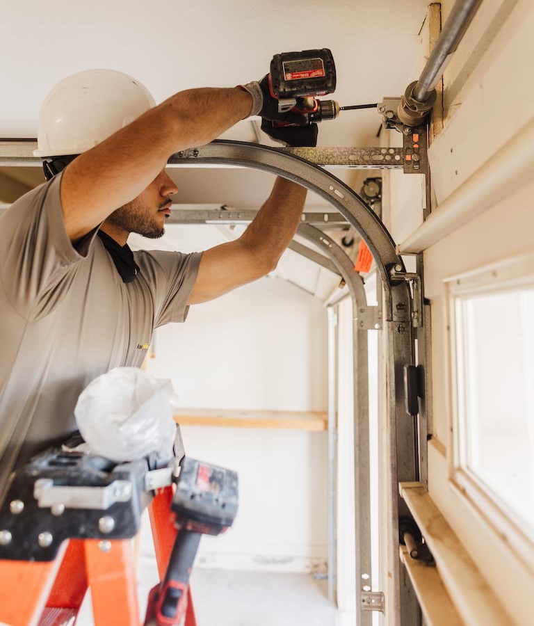 Wayne Dalton Sales & Service technician repairing garage door