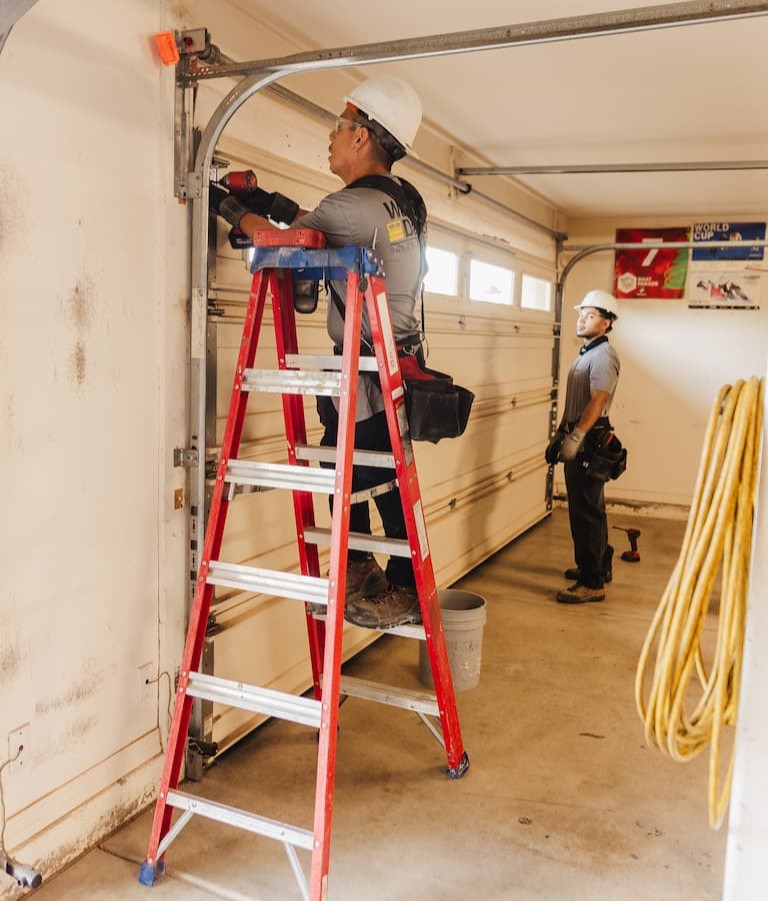 Wayne Dalton Sales & Service technicians maintaining garage door tracks