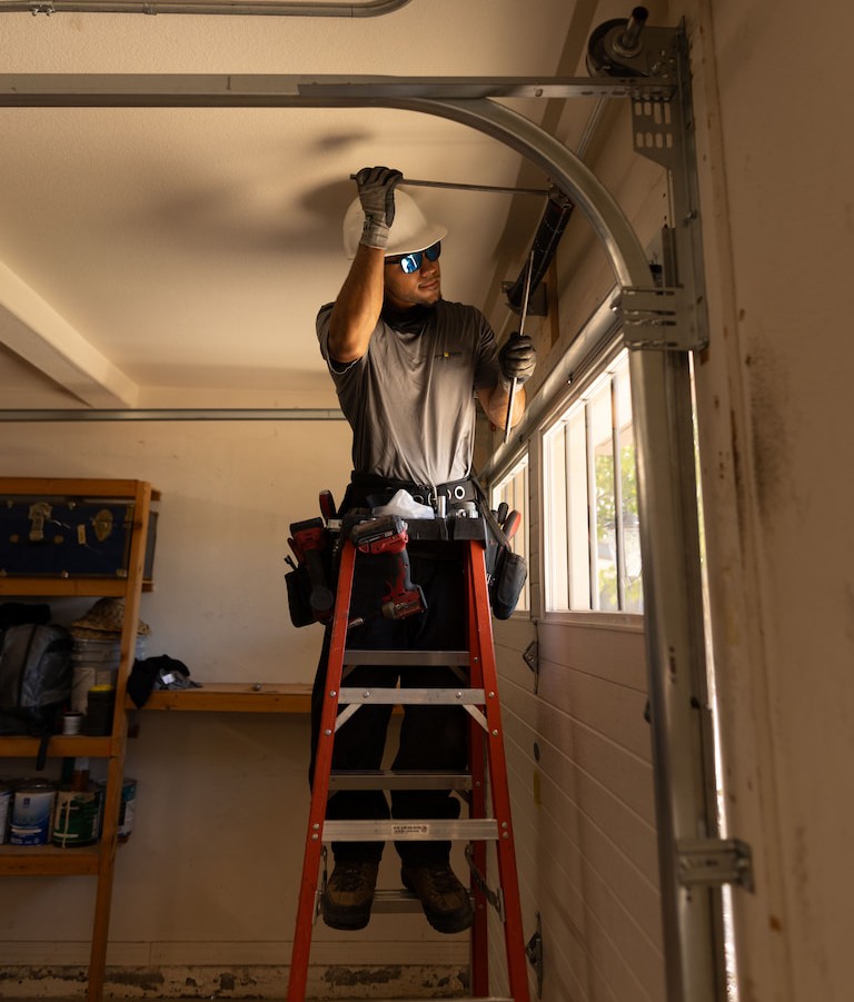 Wayne Dalton Sales & Service technician adjusting garage door springs