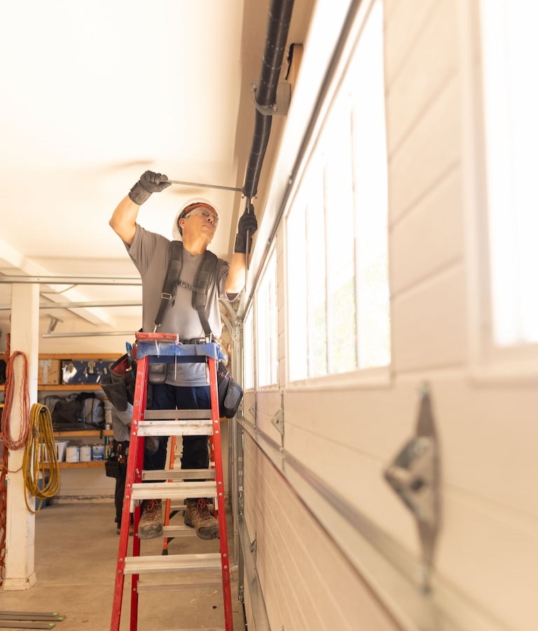 Wayne Dalton Sales & Service technician repairing garage door springs