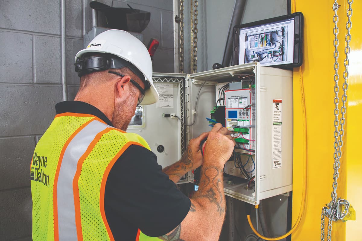 Wayne Dalton Sales & Service technician repairs a commercial door control panel