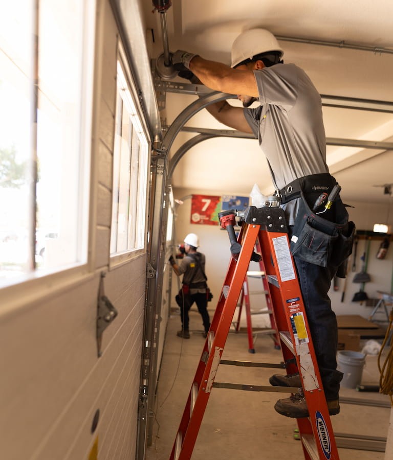 Wayne Dalton Sales & Service technician replacing garage door cable drum