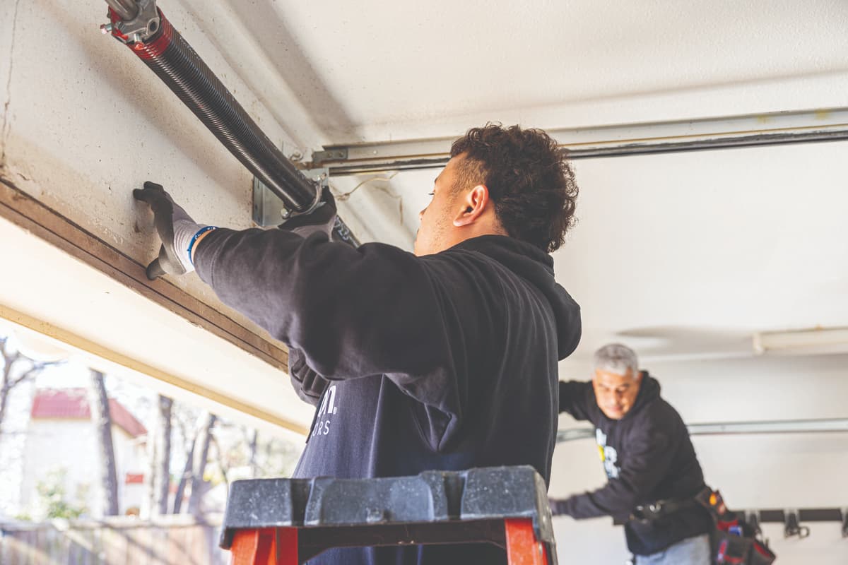 Wayne Dalton Sales & Service technicians replacing garage door spring