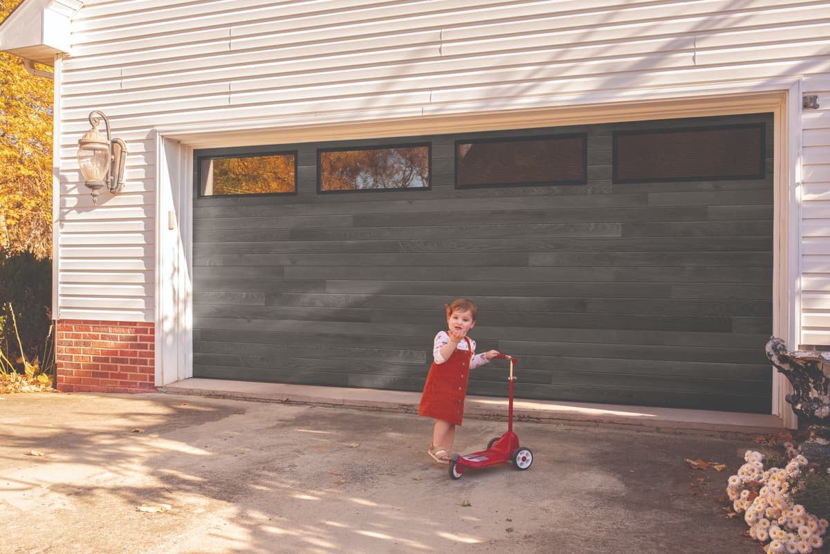young girl on scooter in front of Wayne Dalton 8300 carbon oak garage door